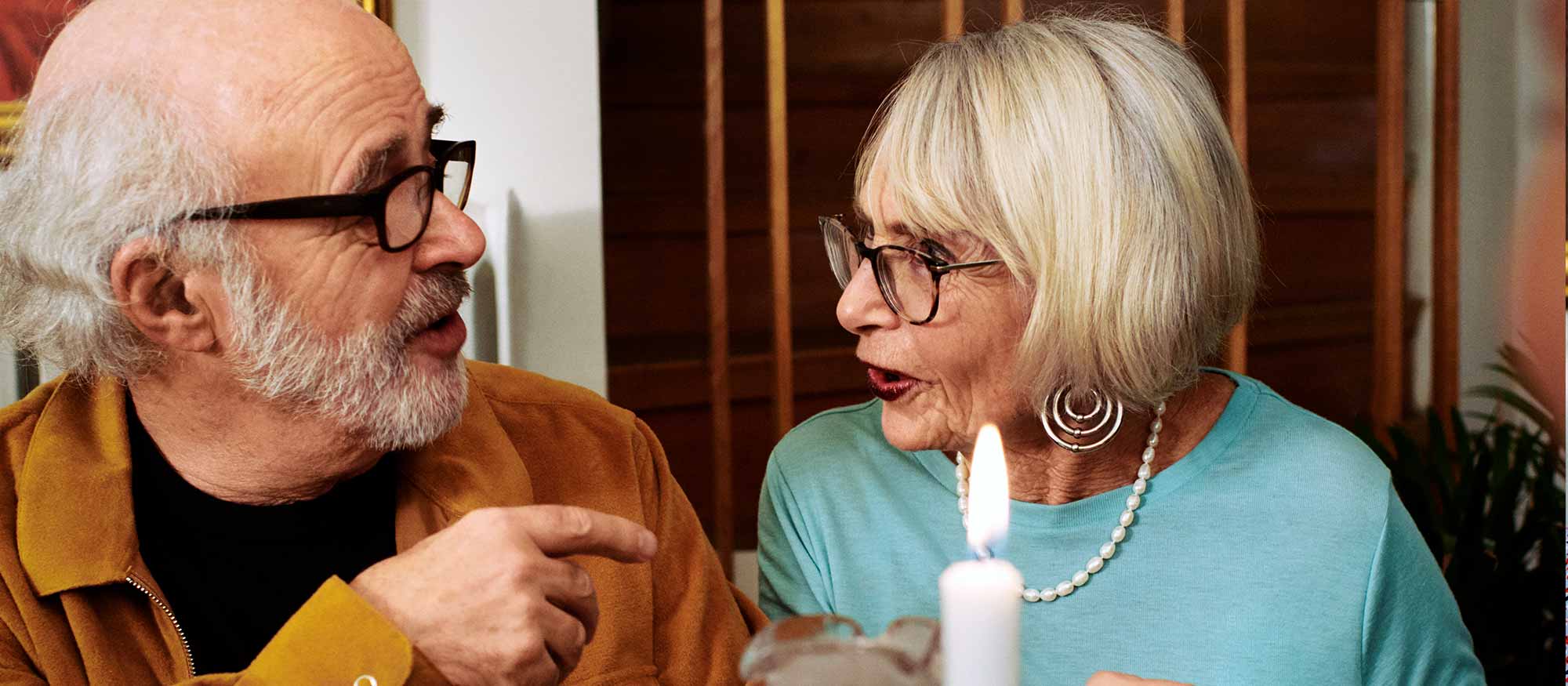 Äldre par pratar med varandra under middagsbjudningen